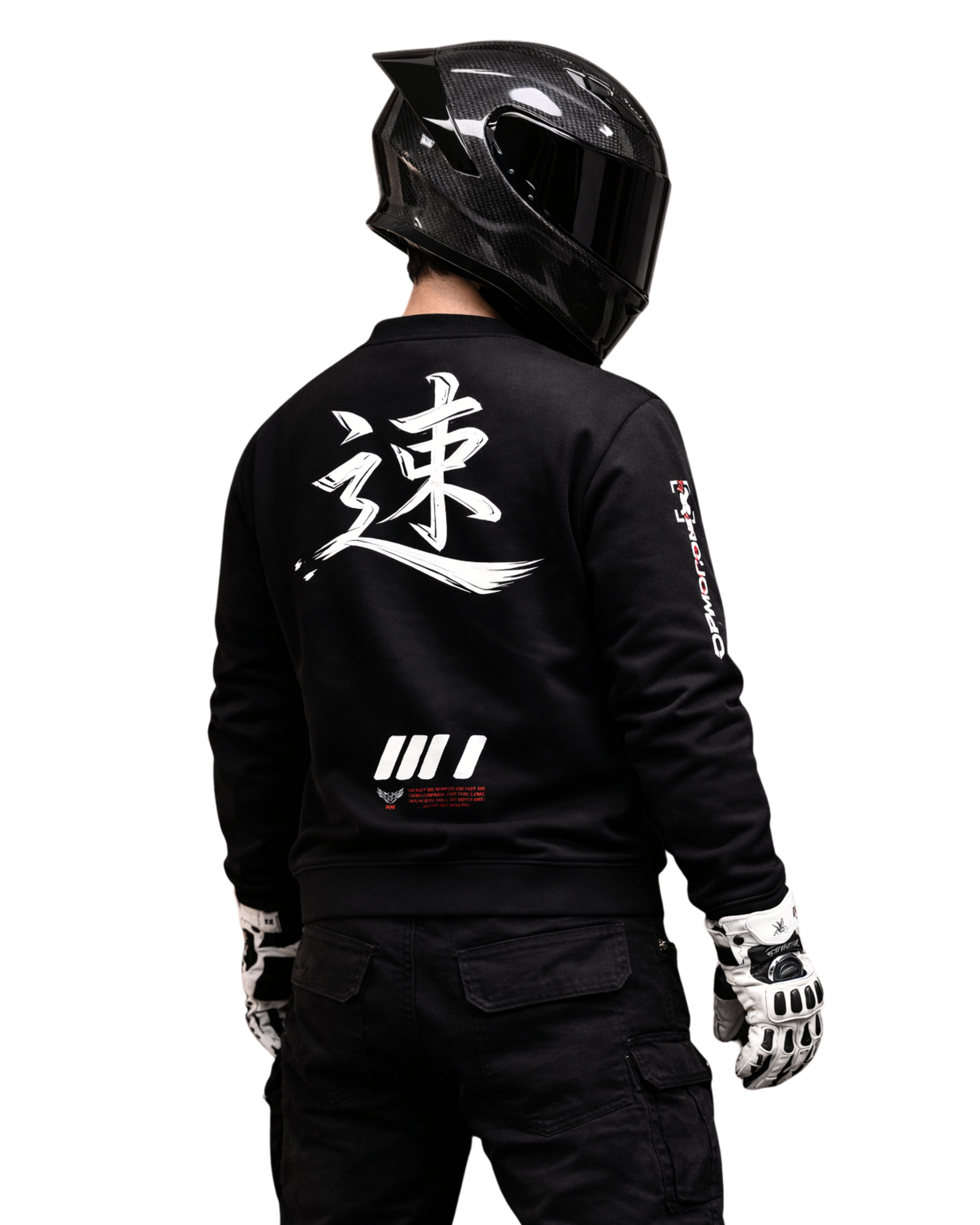 Motorcycle rider wearing black streetwear sweatshirt with bold back graphic and carbon full-face helmet, photographed from behind in dark studio, motorsport culture and speed-driven lifestyle.
